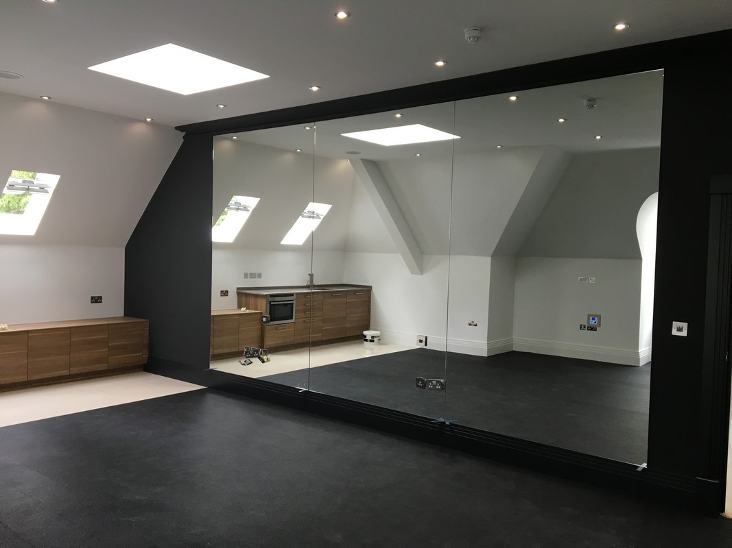Frameless glass wall dividing loft conversion in Cobham